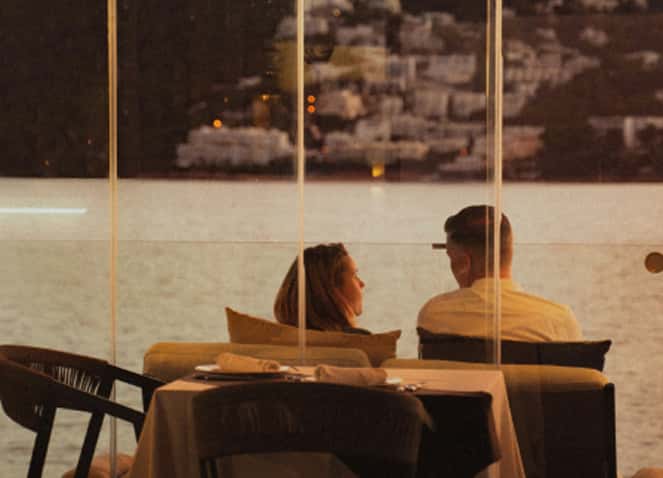 Couple dining on deck at sunset